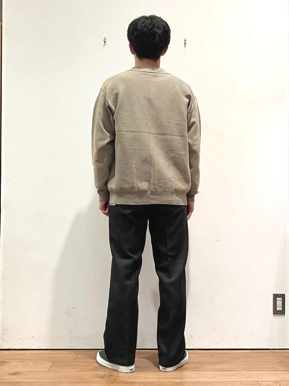 ブラウン系のカーディガン/ボレロ、ブラック系のTシャツ/カットソー、グリーン系のスニーカーを着用したメンズの秋コーディネートの3枚目の写真