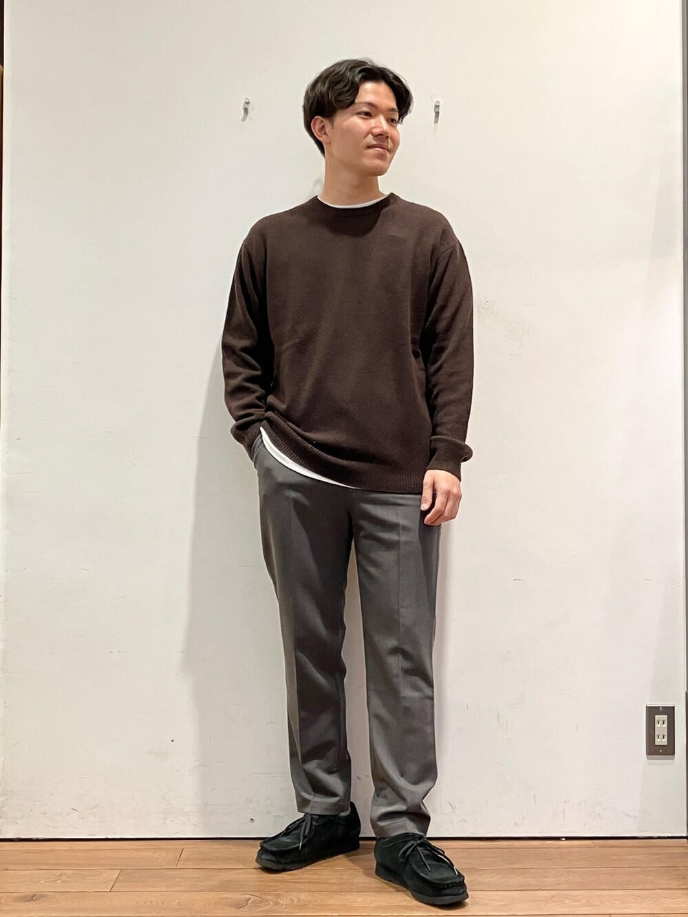 ブラウン系のダウンジャケット/コート、グレー系のその他パンツ、ブラウン系のニット/セーターを着用したメンズの冬コーディネートの5枚目の写真