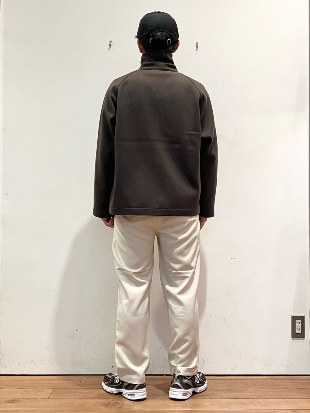 ブラウン系のその他アウター、ブラウン系のニット/セーター、ホワイト系のパンツを着用したメンズの秋コーディネートの4枚目の写真
