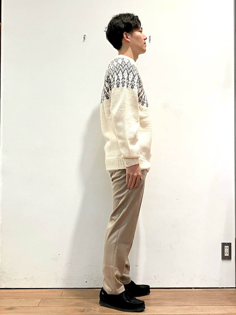 ブラック系のダウンジャケット/コート、ホワイト系のニット/セーター、ブラウン系のその他パンツを着用したメンズの冬コーディネートの5枚目の写真