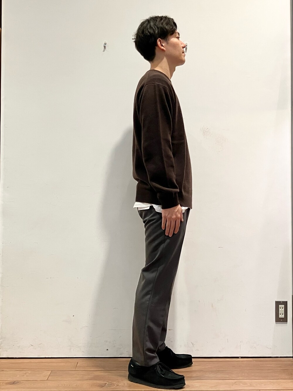 ブラウン系のダウンジャケット/コート、グレー系のその他パンツ、ブラウン系のニット/セーターを着用したメンズの冬コーディネートの6枚目の写真