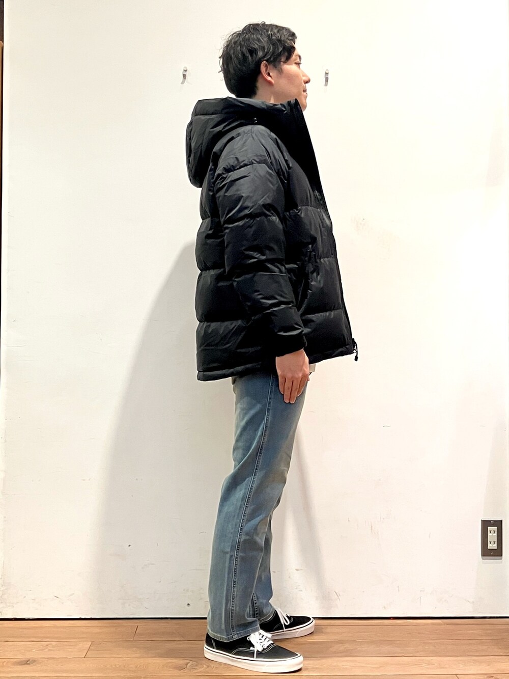 ブラック系のダウンジャケット/コート、ベージュ系のスウェット、ブルー系のその他パンツを着用したメンズの秋コーディネートの2枚目の写真