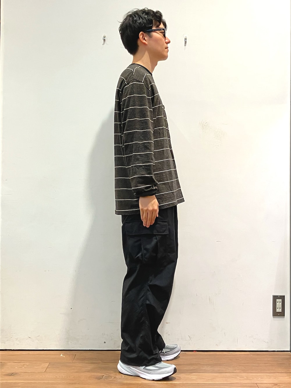 ブラック系のTシャツ/カットソー、ブラック系のカーゴパンツ、グレー系のスニーカーを着用したメンズの秋コーディネートの2枚目の写真