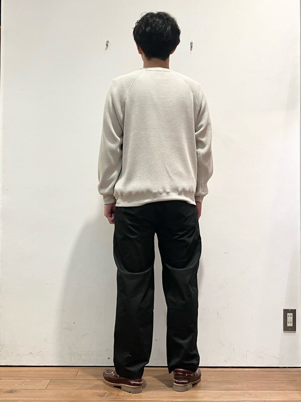 レッド系のダウンジャケット/コート、ベージュ系のTシャツ/カットソー、ブラック系のチノパンツを着用したメンズの秋コーディネートの7枚目の写真