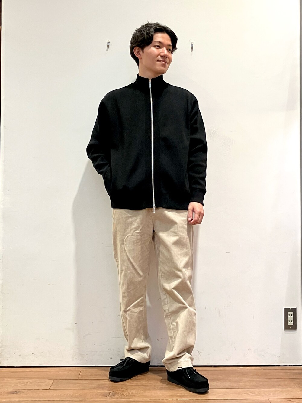 ブラウン系のその他アウター、ブラック系のニット/セーター、ホワイト系のその他パンツを着用したメンズの秋コーディネートの4枚目の写真