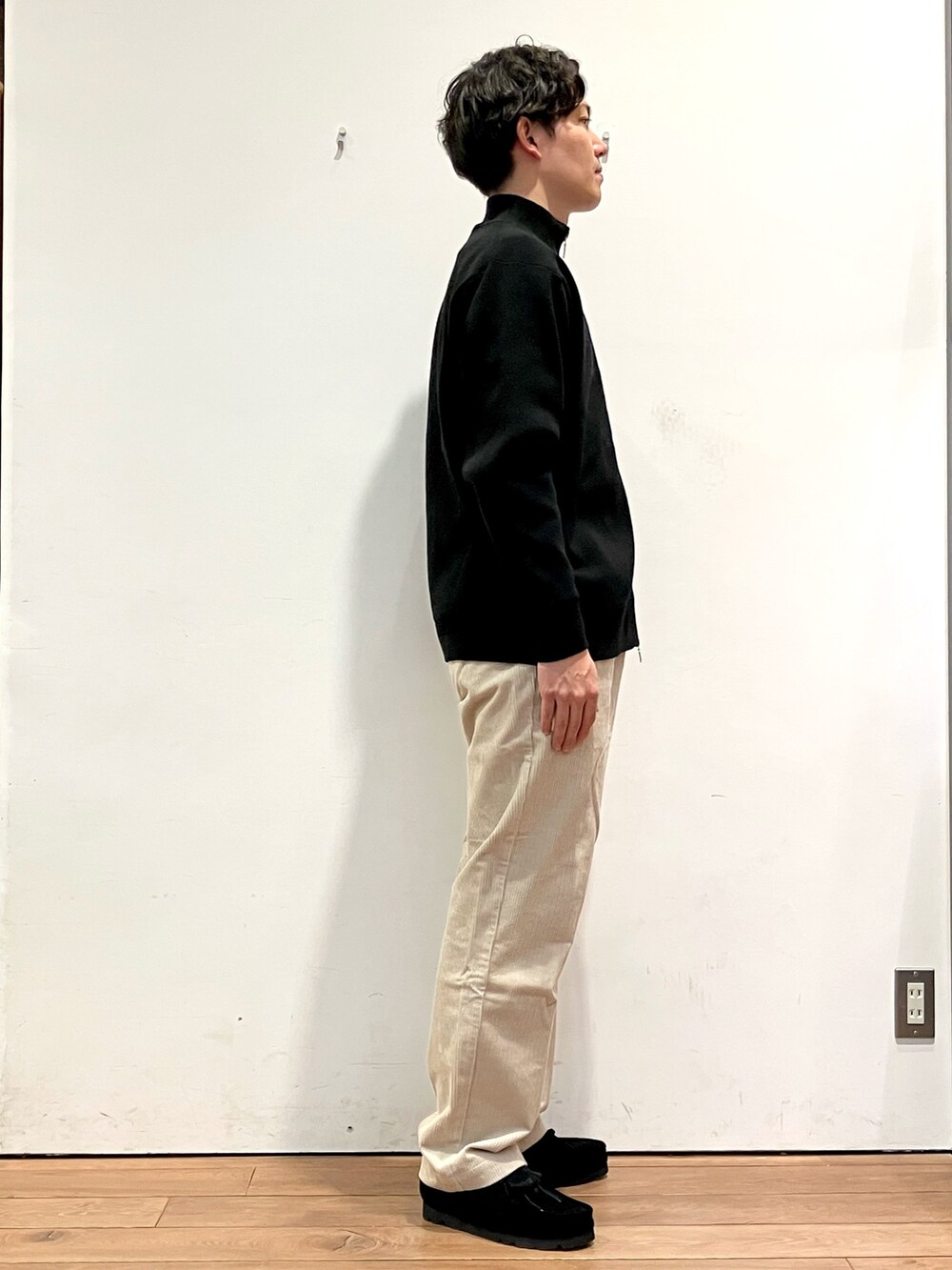 ブラウン系のその他アウター、ブラック系のニット/セーター、ホワイト系のその他パンツを着用したメンズの秋コーディネートの5枚目の写真