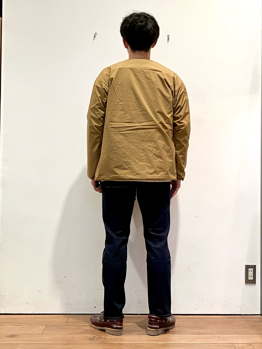 ブラウン系のその他アウター、ブルー系のその他パンツ、レッド系のスニーカーを着用したメンズの秋コーディネートの3枚目の写真