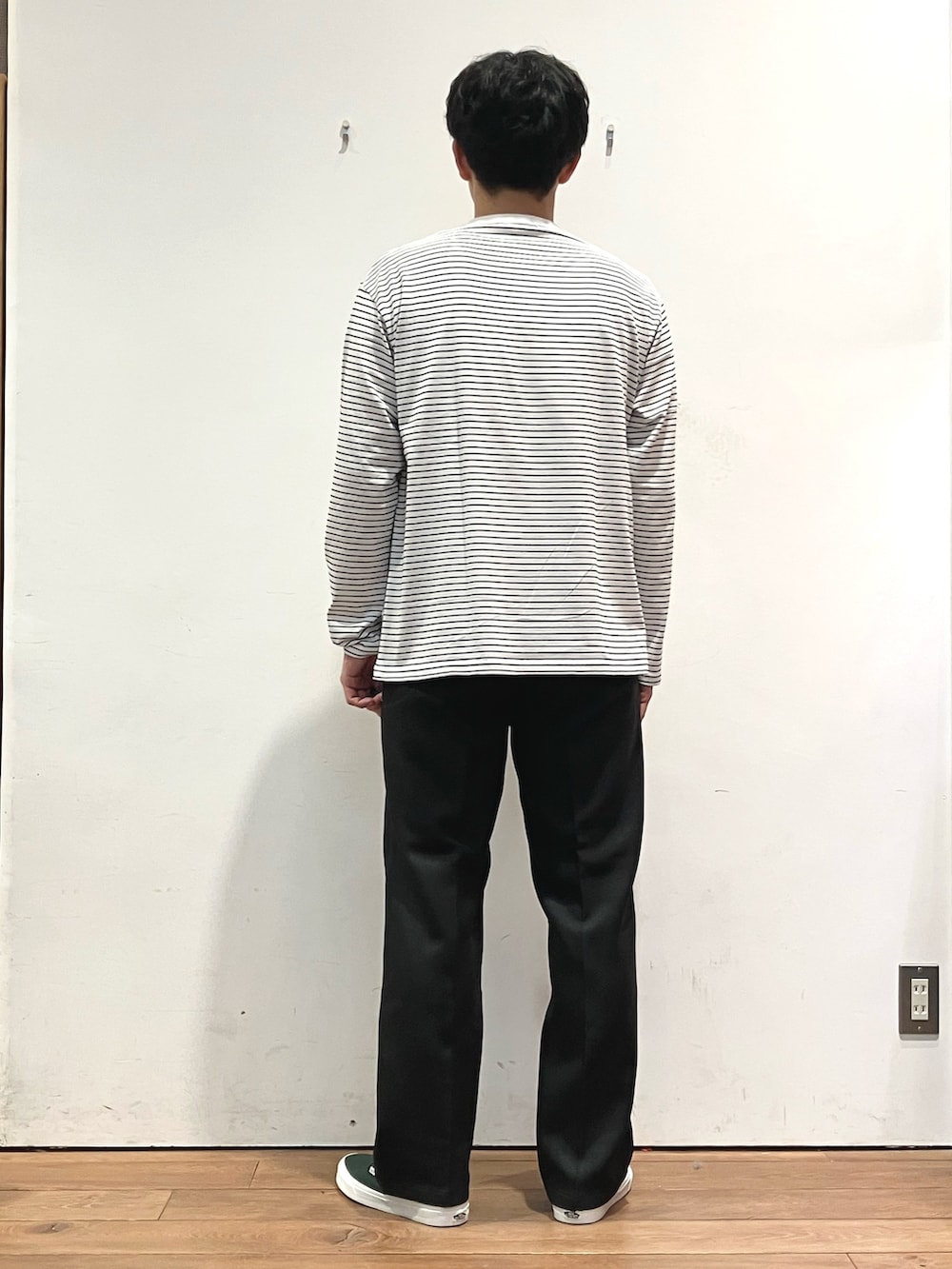 ブラウン系のカーディガン/ボレロ、ブラック系のTシャツ/カットソー、グリーン系のスニーカーを着用したメンズの秋コーディネートの6枚目の写真