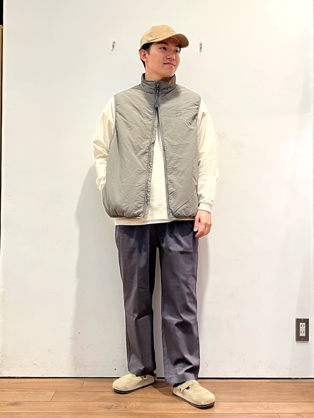 ベージュ系のダウンベスト、ベージュ系のスウェット、グレー系のその他パンツを着用したメンズの秋コーディネートの2枚目の写真