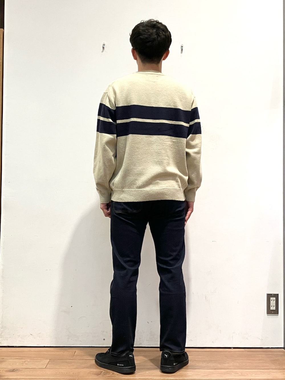 ホワイト系のニット/セーター、ブラック系のダウンジャケット/コート、ブルー系のその他パンツを着用したメンズの冬コーディネートの7枚目の写真