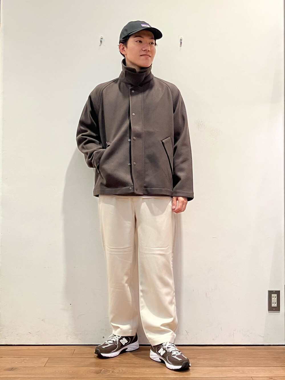 ブラウン系のその他アウター、ブラウン系のニット/セーター、ホワイト系のパンツを着用したメンズの秋コーディネートの2枚目の写真
