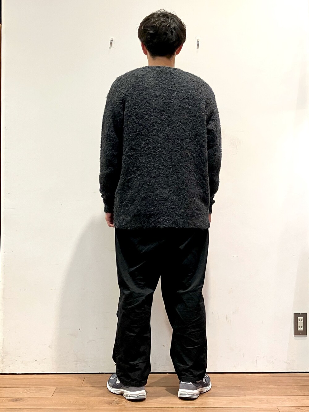 ブルー系のカーディガン/ボレロ、ベージュ系のTシャツ/カットソー、ブラック系のチノパンツを着用したメンズの秋コーディネートの3枚目の写真