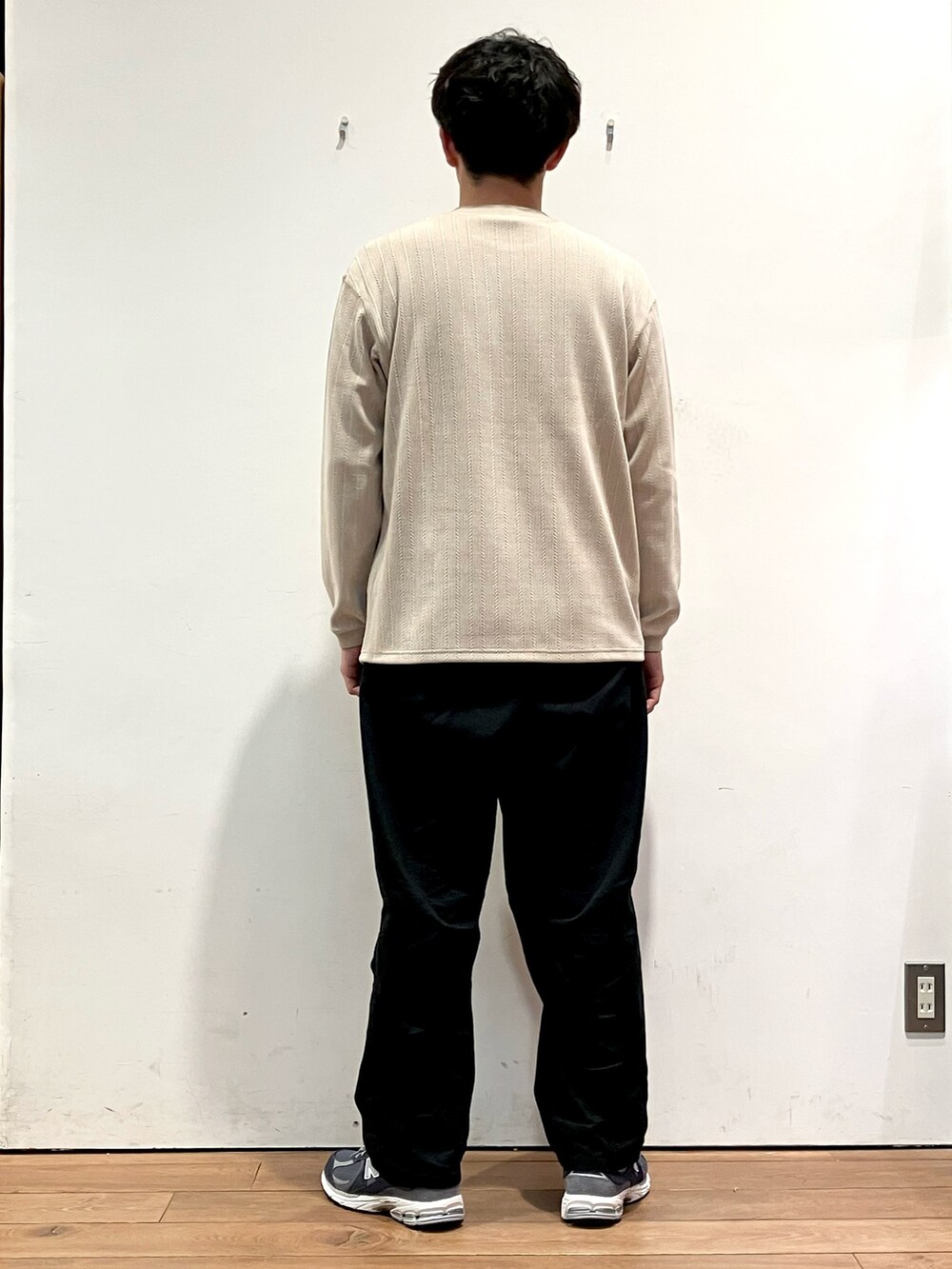 ブルー系のカーディガン/ボレロ、ベージュ系のTシャツ/カットソー、ブラック系のチノパンツを着用したメンズの秋コーディネートの6枚目の写真