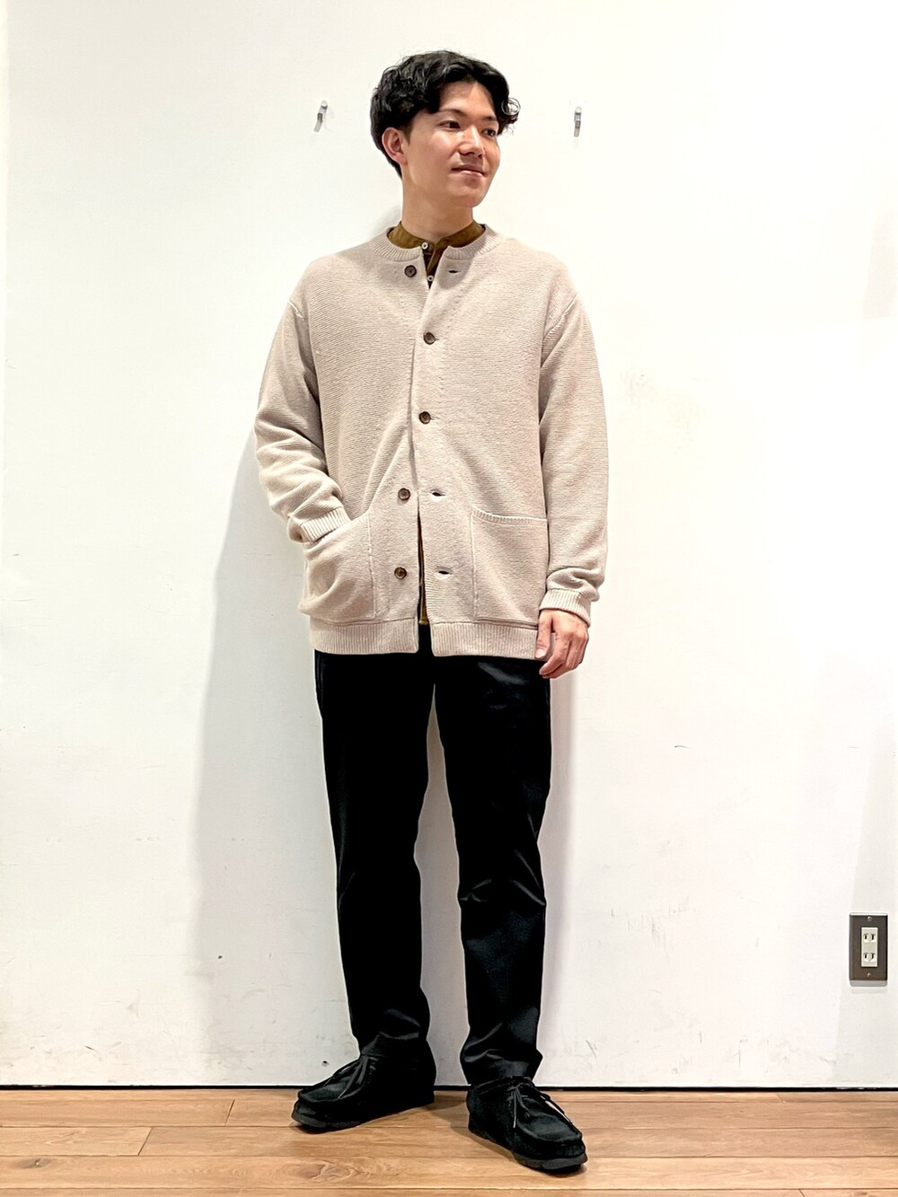 ベージュ系のカーディガン/ボレロ、ブラウン系のシャツ/ブラウス、ブラック系のチノパンツを着用したメンズの秋コーディネートの2枚目の写真