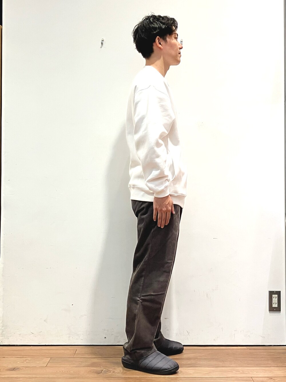 ブラック系のダウンジャケット/コート、ホワイト系のスウェット、ブラウン系のその他パンツを着用したメンズの秋コーディネートの6枚目の写真