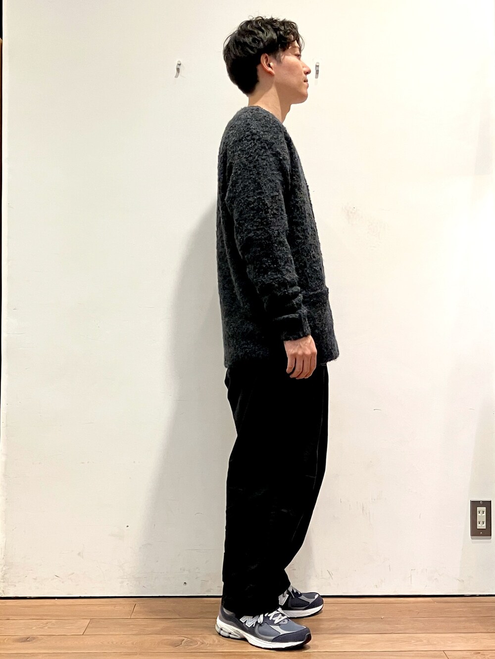 ブルー系のカーディガン/ボレロ、ベージュ系のTシャツ/カットソー、ブラック系のチノパンツを着用したメンズの秋コーディネートの2枚目の写真