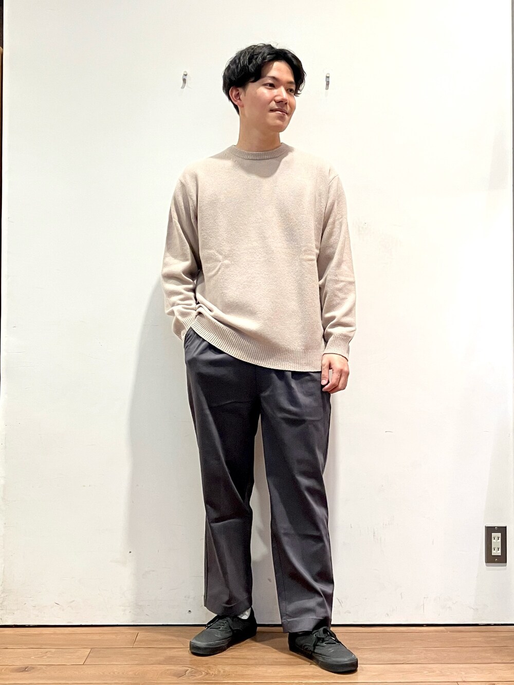 グリーン系のダウンジャケット/コート、ベージュ系のニット/セーター、グレー系のその他パンツを着用したメンズの秋コーディネートの4枚目の写真