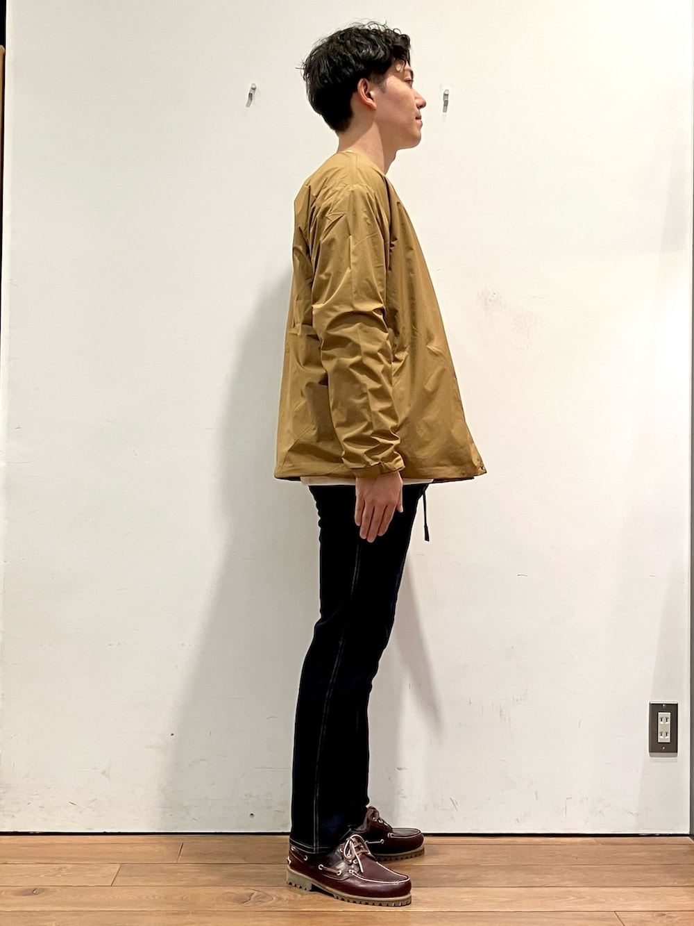 ブラウン系のその他アウター、ブルー系のその他パンツ、レッド系のスニーカーを着用したメンズの秋コーディネートの2枚目の写真