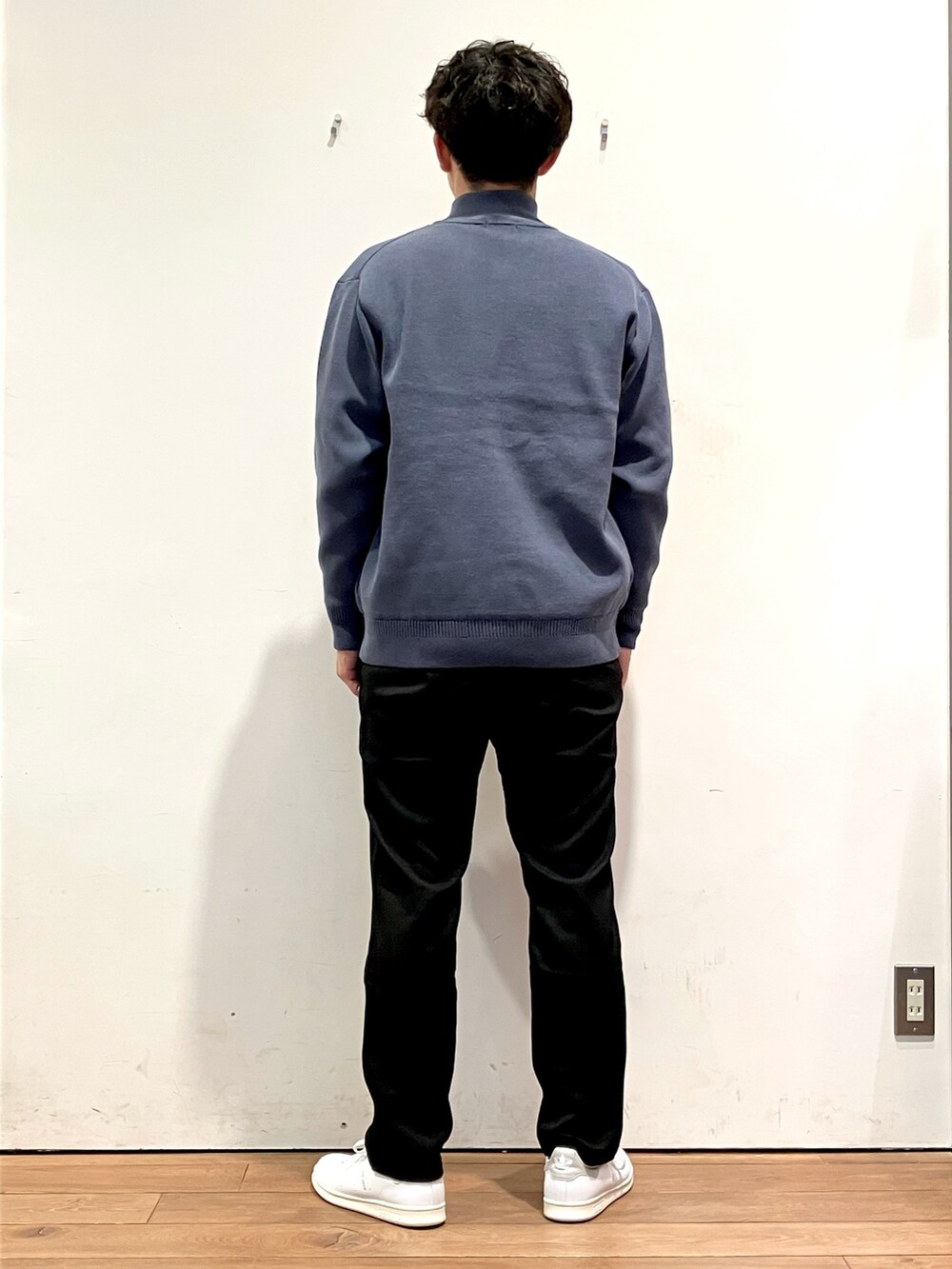 ブルー系のニット/セーター、ブラック系のTシャツ/カットソー、ホワイト系のスニーカーを着用したメンズの秋コーディネートの4枚目の写真