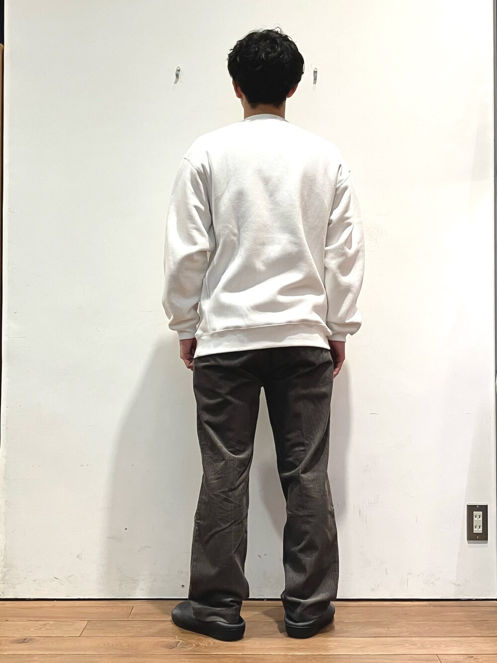 ブラック系のダウンジャケット/コート、ホワイト系のスウェット、ブラウン系のその他パンツを着用したメンズの秋コーディネートの7枚目の写真