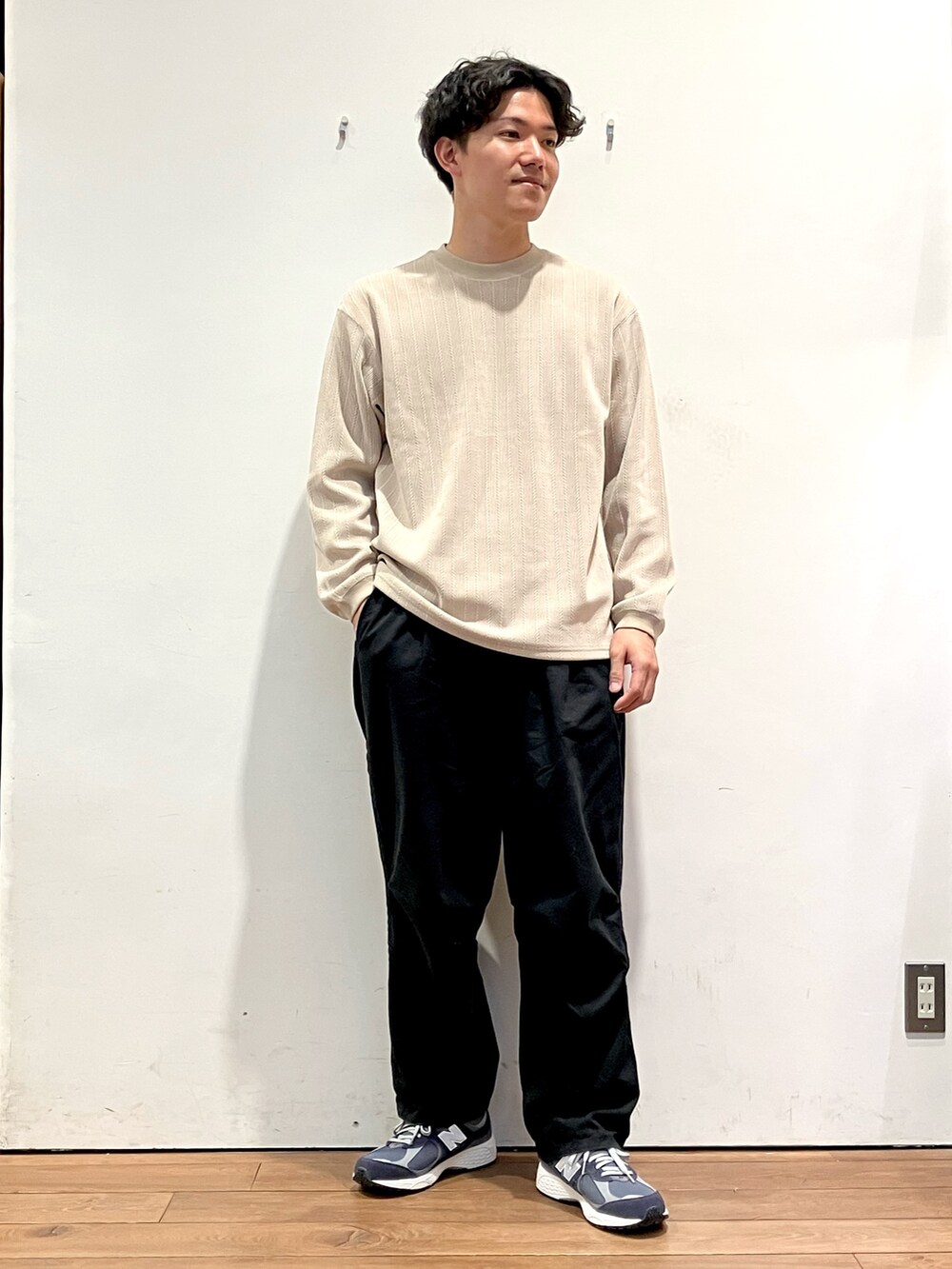 ブルー系のカーディガン/ボレロ、ベージュ系のTシャツ/カットソー、ブラック系のチノパンツを着用したメンズの秋コーディネートの4枚目の写真