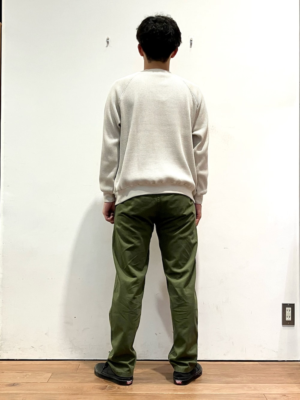 ベージュ系のTシャツ/カットソー、グリーン系のその他パンツ、ブラック系のスニーカーを着用したメンズの秋コーディネートの3枚目の写真