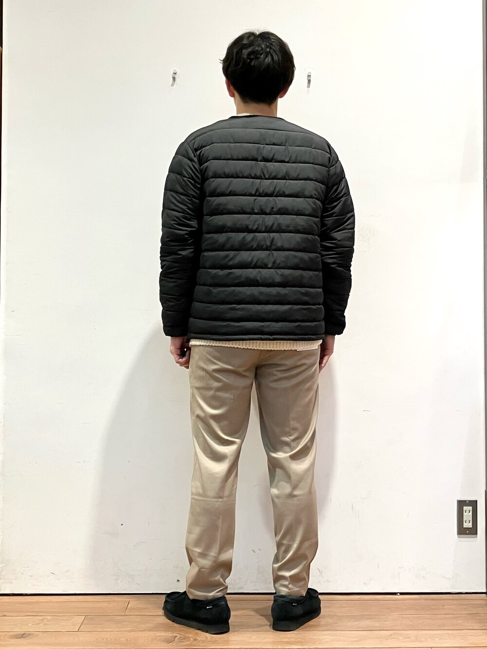 ブラック系のダウンジャケット/コート、ホワイト系のニット/セーター、ブラウン系のその他パンツを着用したメンズの冬コーディネートの3枚目の写真