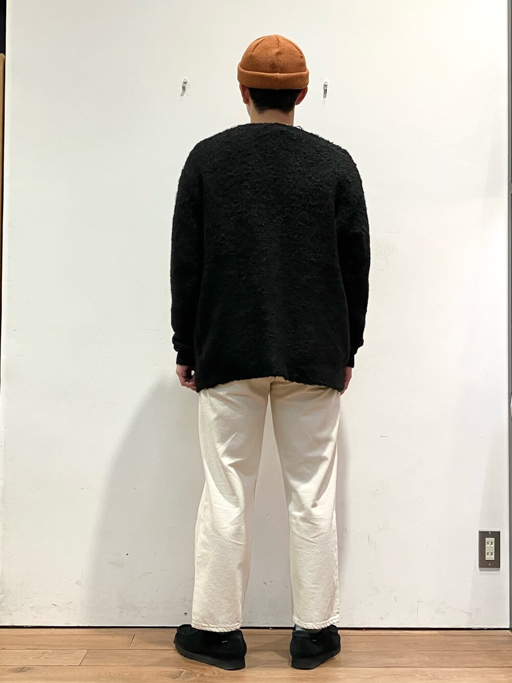 ブラック系のカーディガン/ボレロ、ブラック系のTシャツ/カットソー、ホワイト系のデニムパンツを着用したメンズの秋コーディネートの3枚目の写真