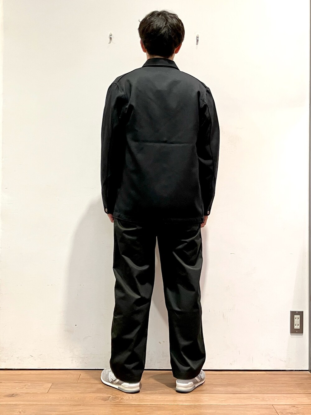 ブラック系のカバーオール、ブラック系のTシャツ/カットソー、ブラック系のチノパンツを着用したメンズの秋コーディネートの3枚目の写真