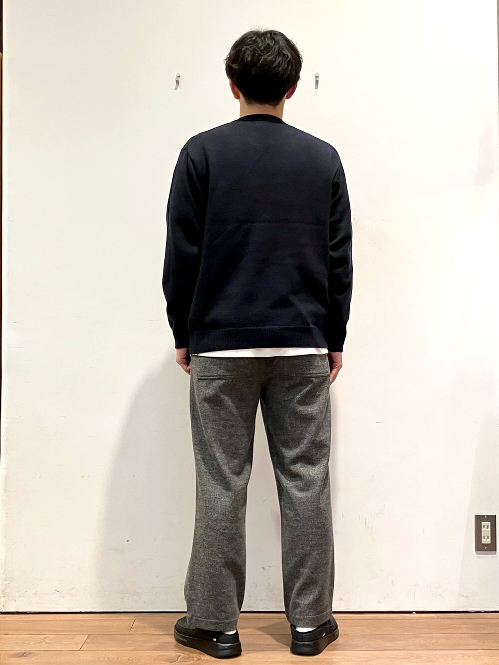 レッド系のダウンジャケット/コート、ブラック系のニット/セーター、グレー系のその他パンツを着用したメンズの秋コーディネートの6枚目の写真