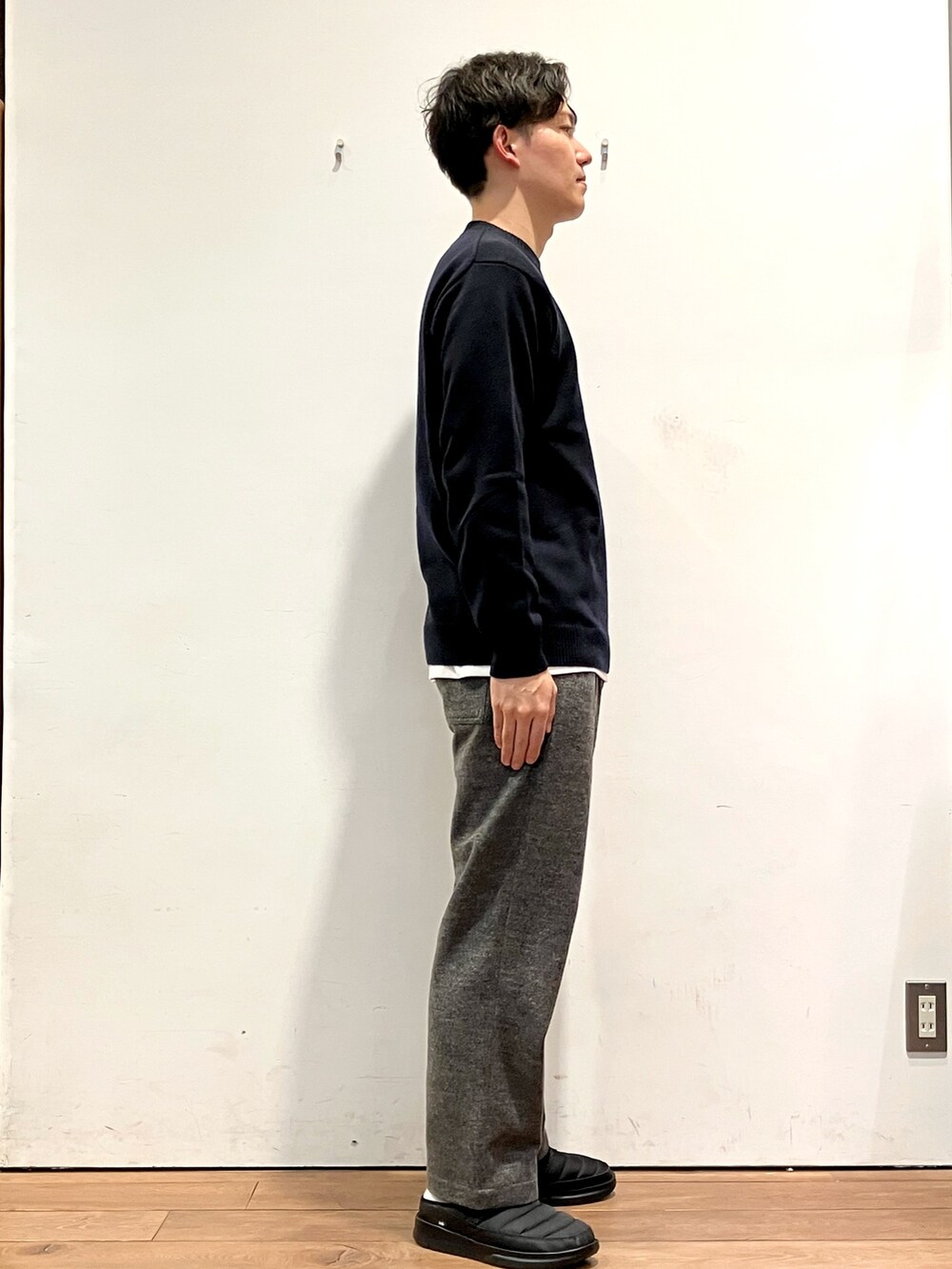 レッド系のダウンジャケット/コート、ブラック系のニット/セーター、グレー系のその他パンツを着用したメンズの秋コーディネートの5枚目の写真