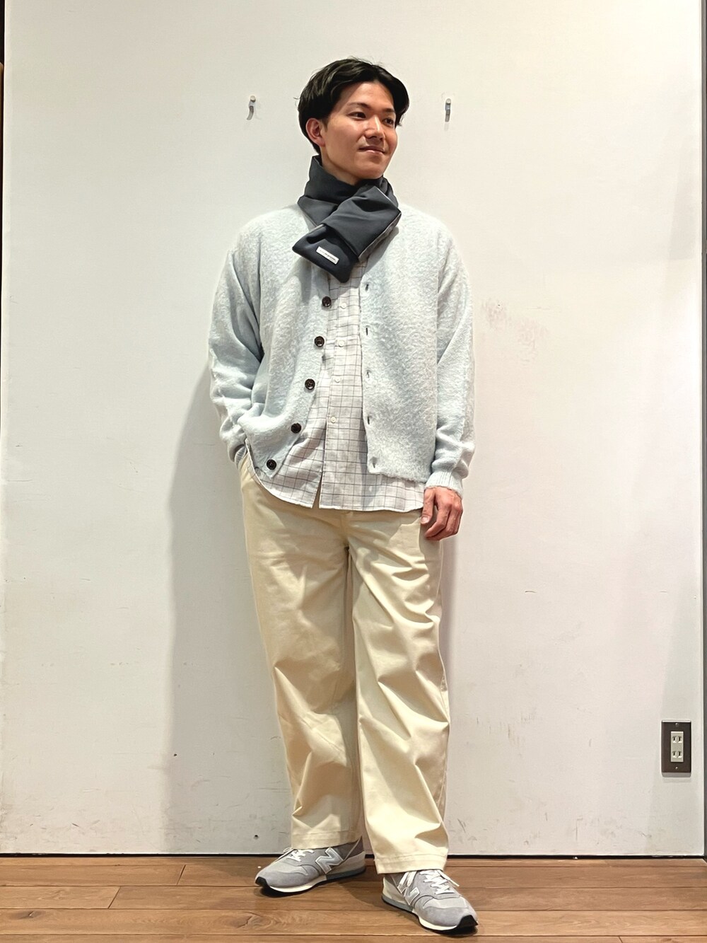 グリーン系のカーディガン/ボレロ、グレー系のシャツ/ブラウス、ホワイト系のチノパンツを着用したメンズの冬コーディネートの2枚目の写真