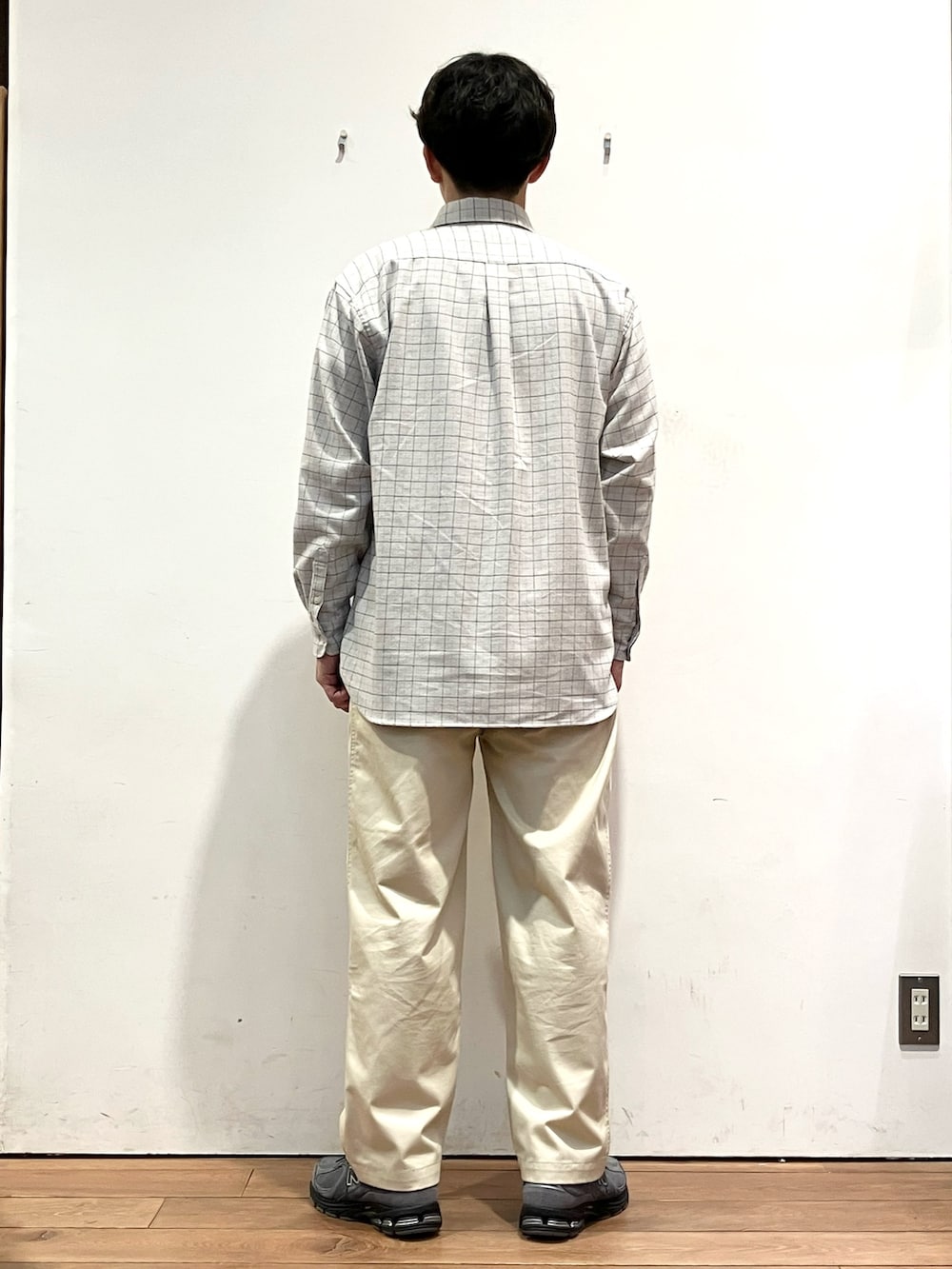 グレー系のスウェット、グレー系のシャツ/ブラウス、ホワイト系のチノパンツを着用したメンズの秋コーディネートの6枚目の写真