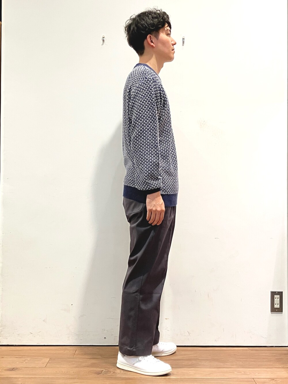 ブルー系のニット/セーター、グレー系のその他パンツ、ホワイト系のスニーカーを着用したメンズの秋コーディネートの2枚目の写真