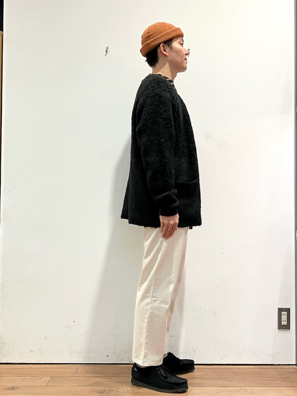 ブラック系のカーディガン/ボレロ、ブラック系のTシャツ/カットソー、ホワイト系のデニムパンツを着用したメンズの秋コーディネートの2枚目の写真