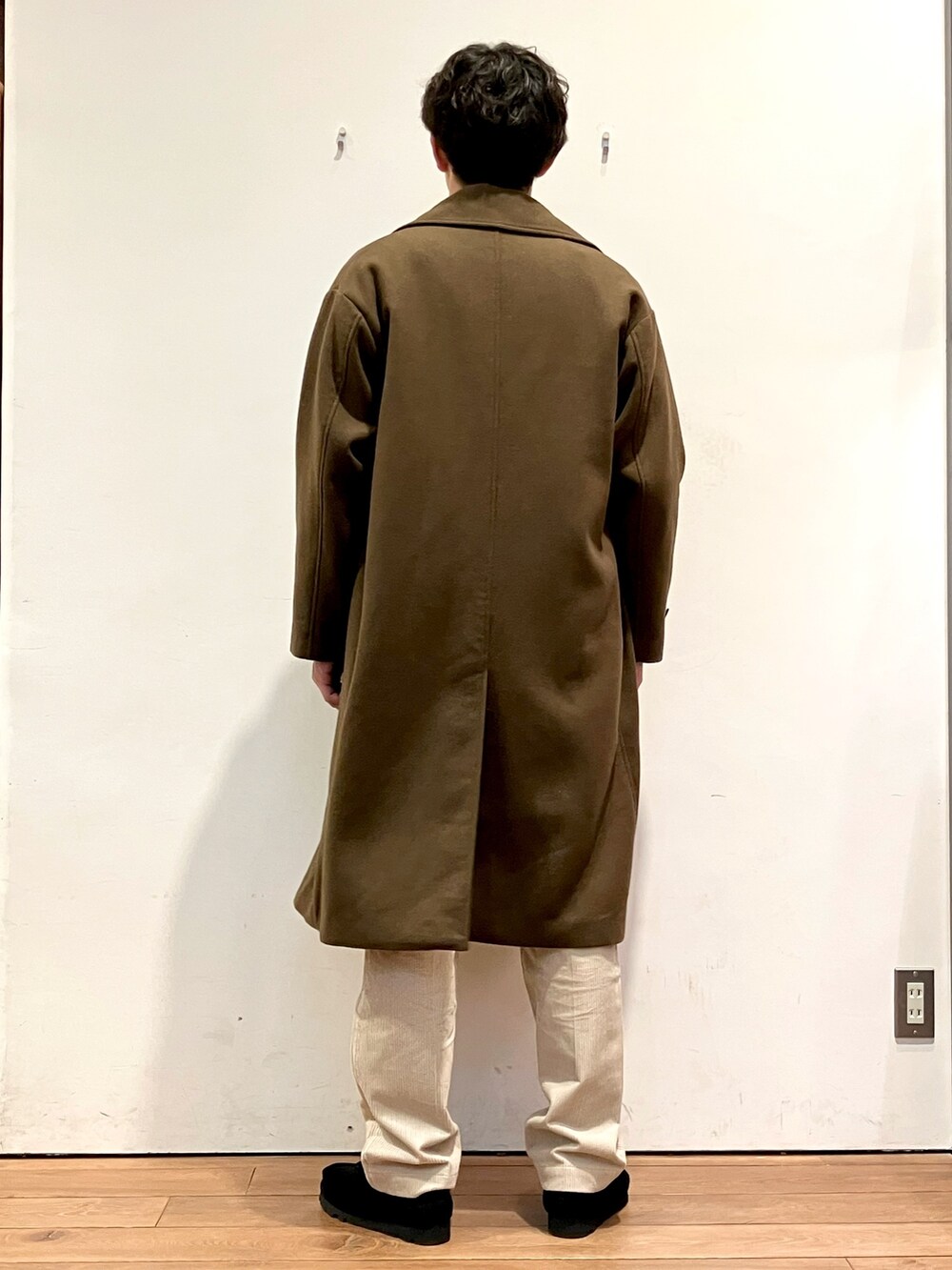 ブラウン系のその他アウター、ブラック系のニット/セーター、ホワイト系のその他パンツを着用したメンズの秋コーディネートの3枚目の写真