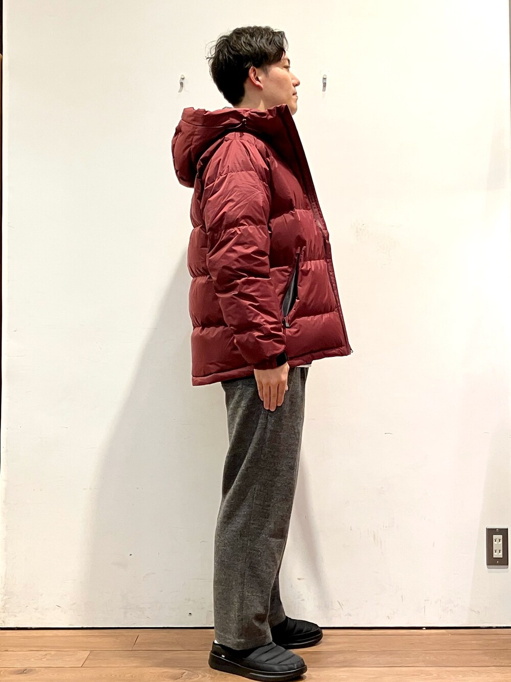 レッド系のダウンジャケット/コート、ブラック系のニット/セーター、グレー系のその他パンツを着用したメンズの秋コーディネートの2枚目の写真