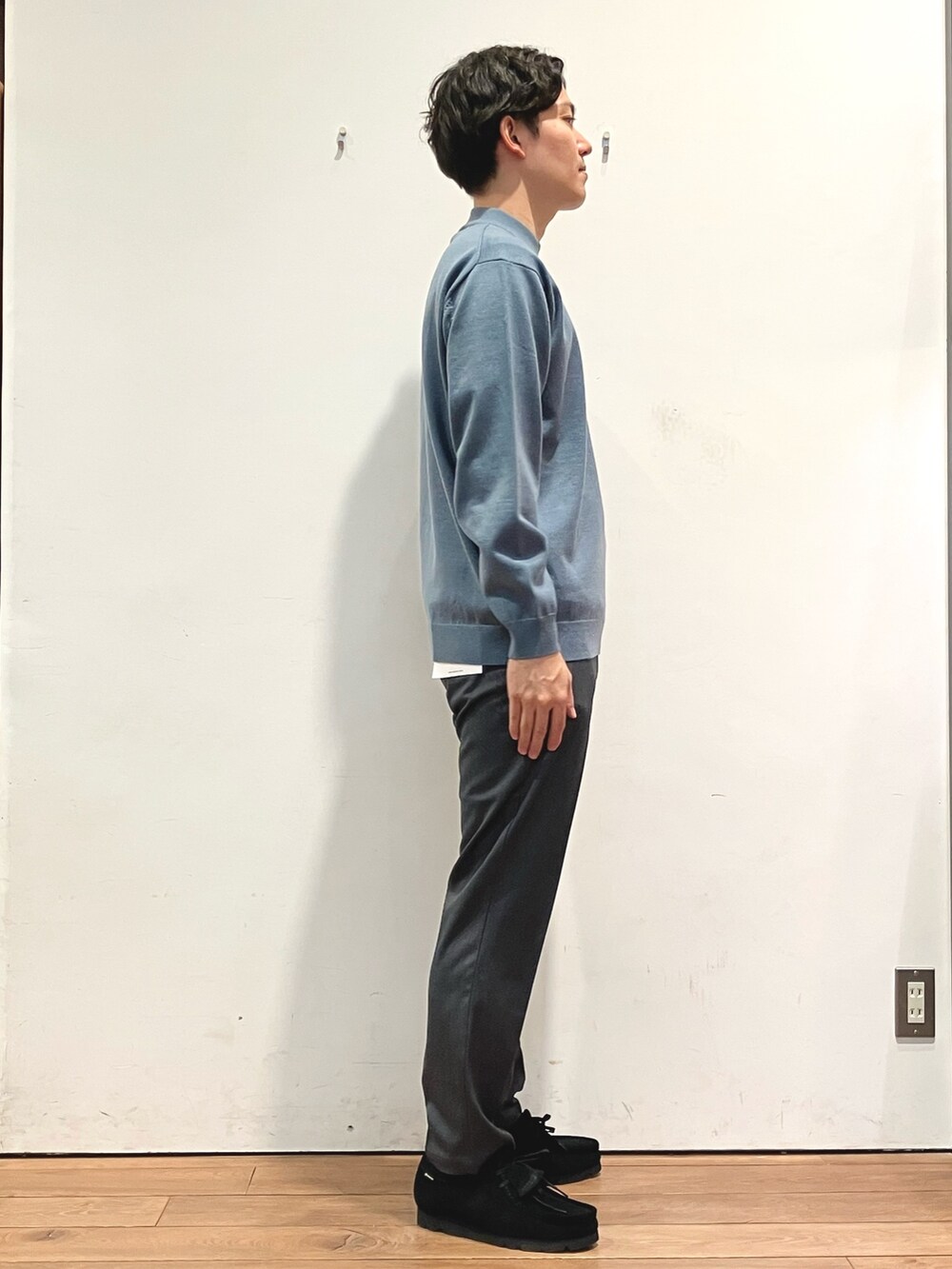 ブラック系のダウンジャケット/コート、ブルー系のニット/セーター、グレー系のその他パンツを着用したメンズの秋コーディネートの5枚目の写真