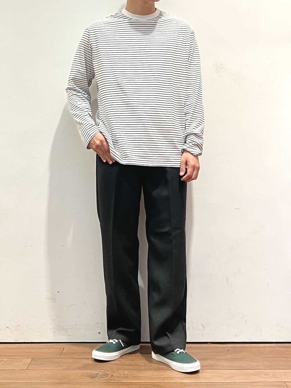 ブラウン系のカーディガン/ボレロ、ブラック系のTシャツ/カットソー、グリーン系のスニーカーを着用したメンズの秋コーディネートの4枚目の写真