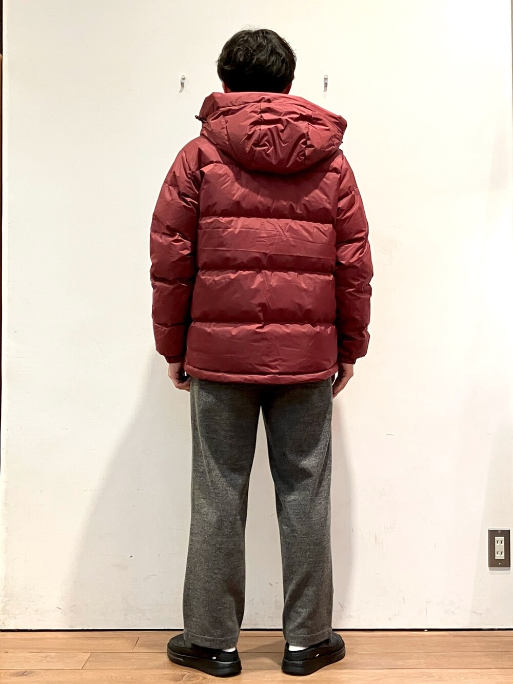レッド系のダウンジャケット/コート、ブラック系のニット/セーター、グレー系のその他パンツを着用したメンズの秋コーディネートの3枚目の写真