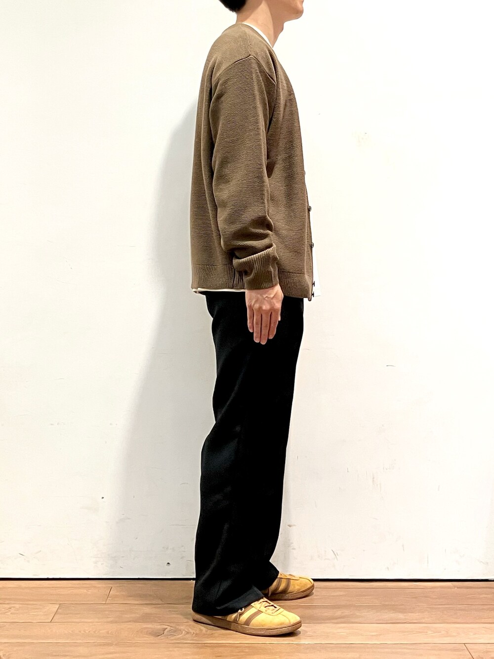 ブラウン系のカーディガン/ボレロ、ホワイト系のTシャツ/カットソー、ブラック系のその他パンツを着用したメンズの秋コーディネートの2枚目の写真