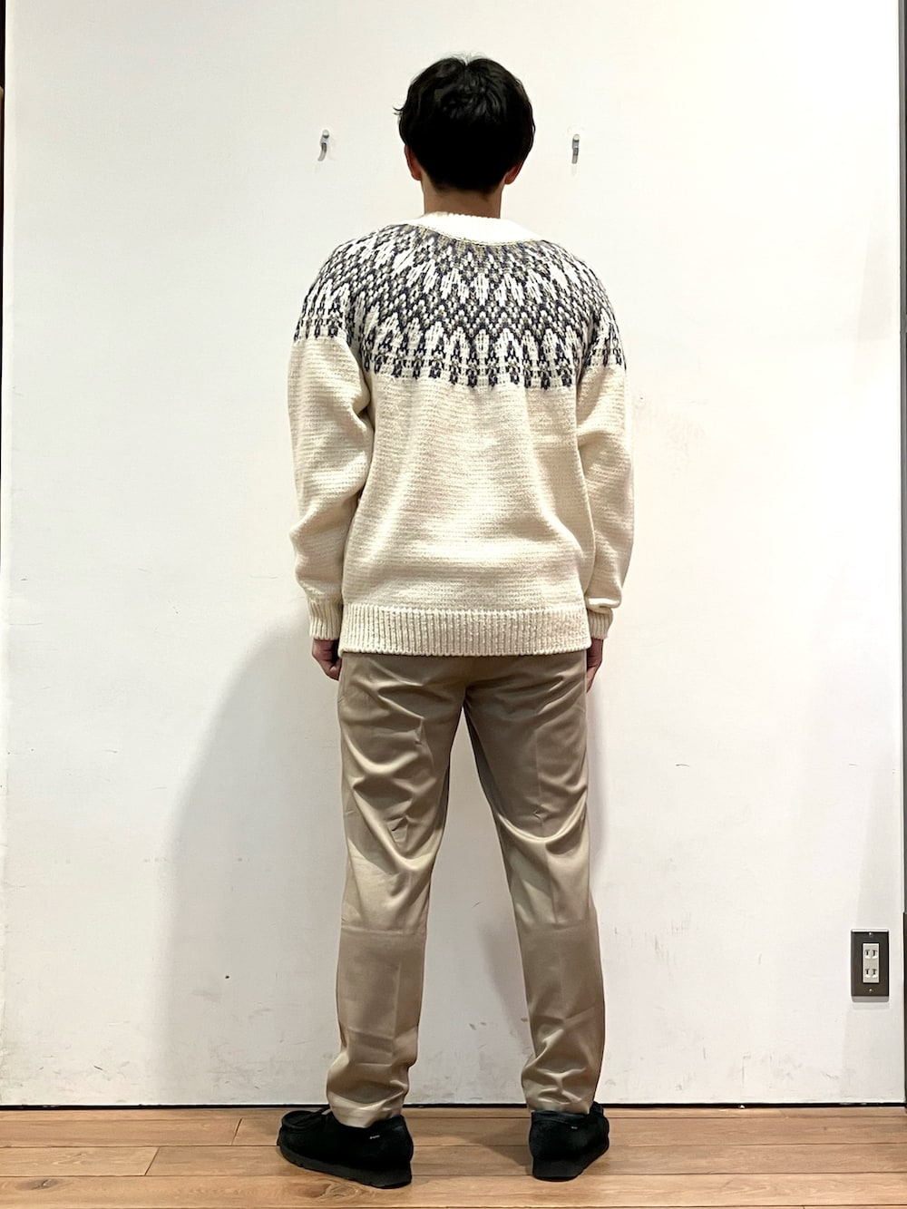 ブラック系のダウンジャケット/コート、ホワイト系のニット/セーター、ブラウン系のその他パンツを着用したメンズの冬コーディネートの6枚目の写真