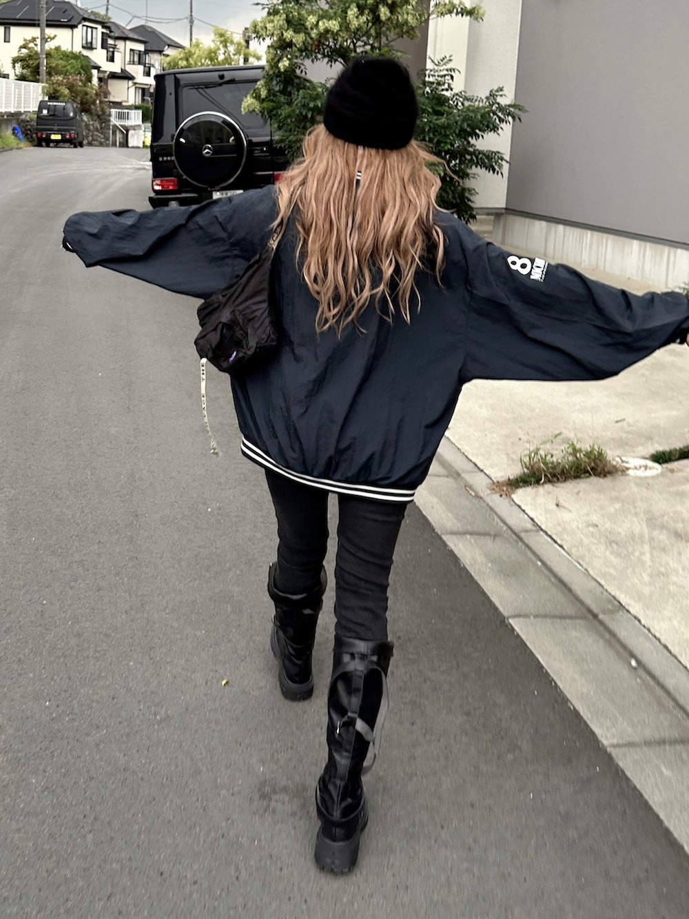 ブラック系のパーカー、ブラック系のデニムパンツ、ブラック系のボディバッグ/ウエストポーチを着用したレディースの秋コーディネートの3枚目の写真