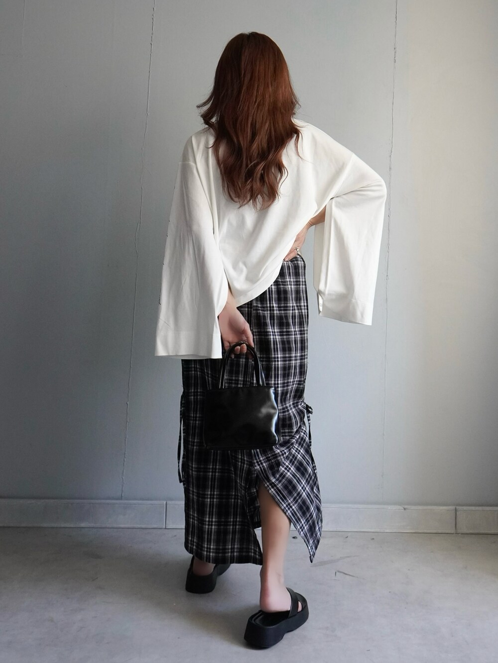 ブラック系のサンダル、ブラック系のスカート、ホワイト系のTシャツ/カットソーを着用したレディースの春コーディネートの4枚目の写真