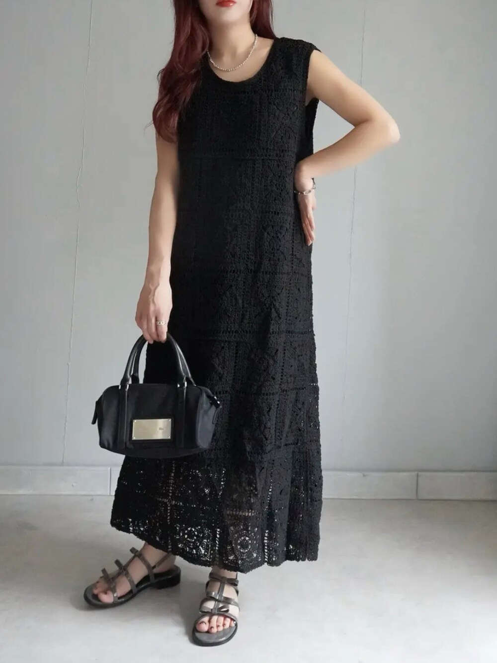 ブラック系のサンダル、ブラック系のワンピース、ブラック系のカーディガン/ボレロを着用したレディースの夏コーディネートの2枚目の写真