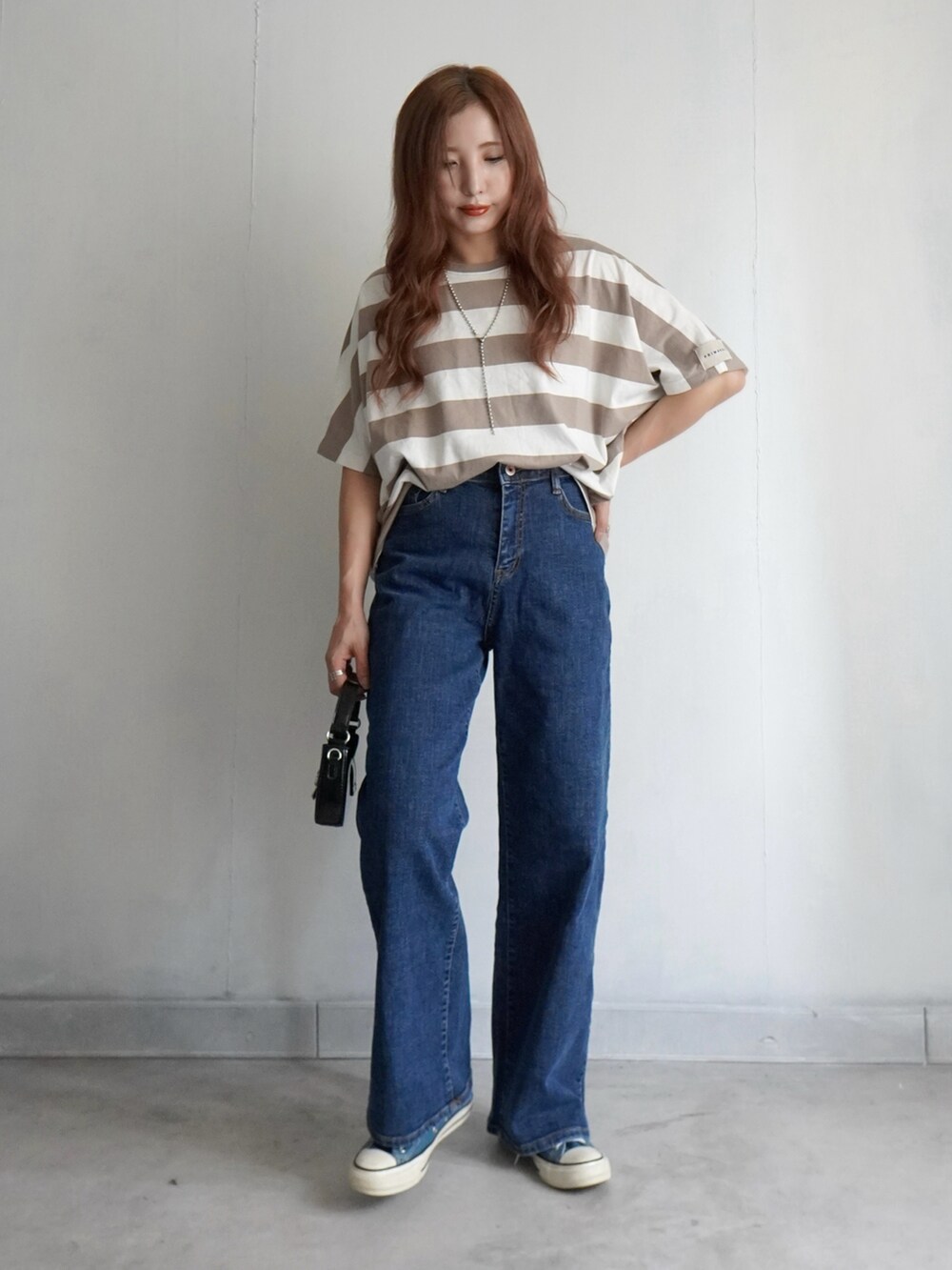 ブルー系のデニムパンツ、シルバー系のスニーカー、ブルー系のTシャツ/カットソーを着用したレディースの夏コーディネートの5枚目の写真