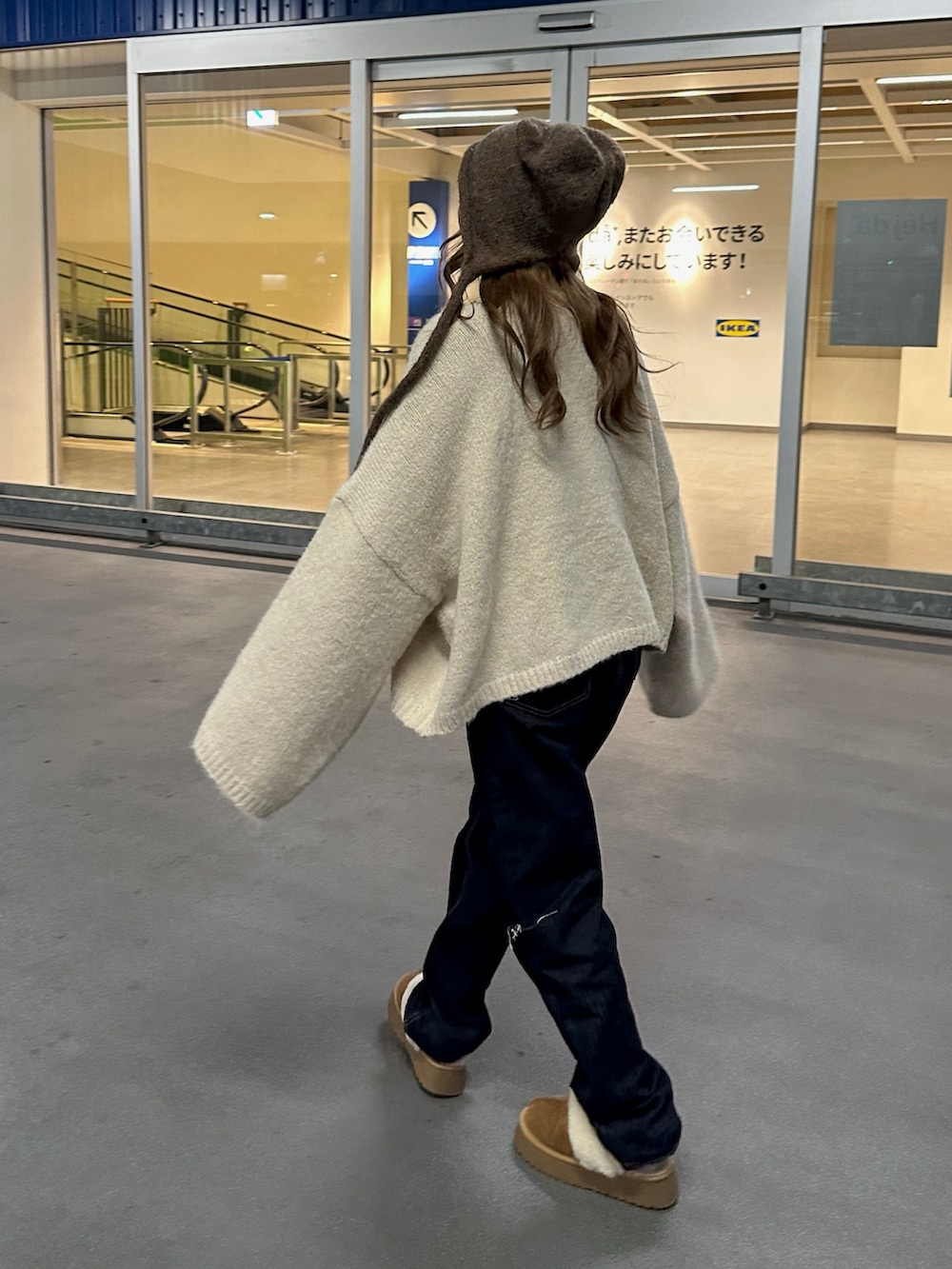 ブルー系のデニムパンツ、ベージュ系のニット/セーター、ブルー系のデニムパンツを着用したレディースの冬コーディネートの5枚目の写真