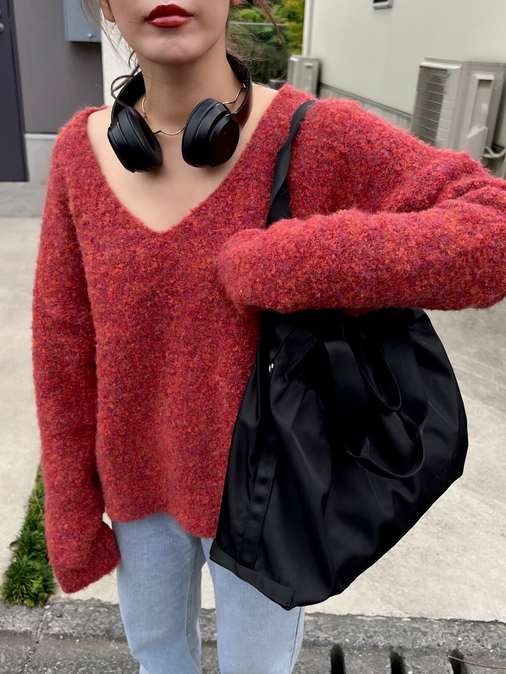 ホワイト系のスニーカー、レッド系のニット/セーター、ブルー系のデニムパンツを着用したレディースの夏コーディネートの5枚目の写真