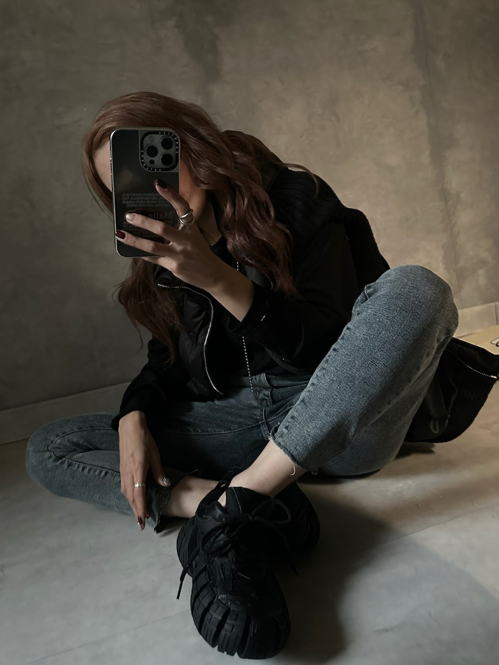 ブラック系のダウンベスト、ブラック系のTシャツ/カットソー、グレー系のセットアップを着用したレディースの冬コーディネートの2枚目の写真