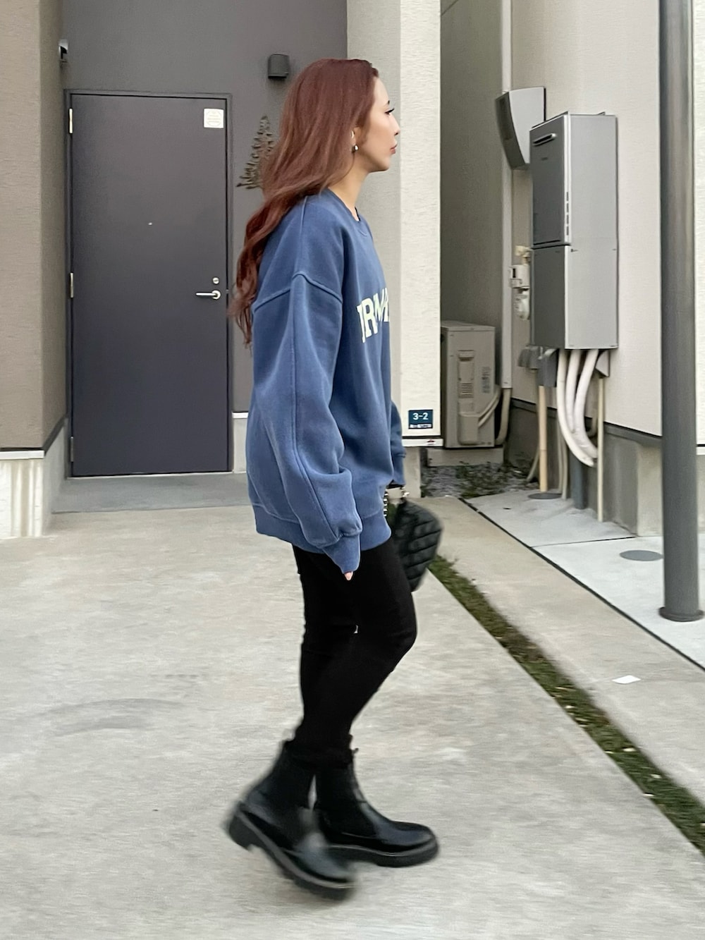 ブルー系のスウェット、ブラック系のデニムパンツ、ブラック系のデニムパンツを着用したレディースの冬コーディネートの2枚目の写真